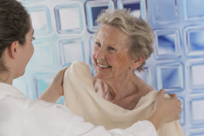 caregiver helping senior woman on shower